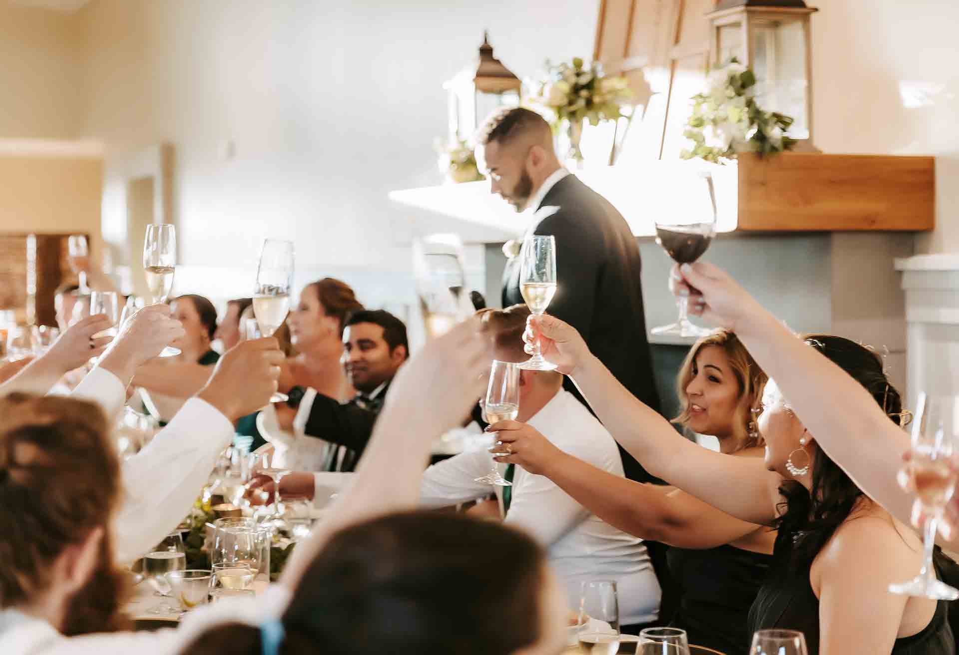 A joyful wedding toast at Paradise Ridge Winery, celebrating love in the stunning Vine Room.